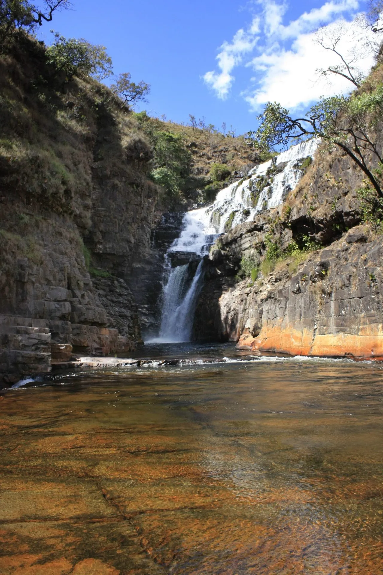 Cachoeira dos Macaquinhos com queda d'água entre rochas e poço de águas cristalinas na Chapada dos Veadeiros