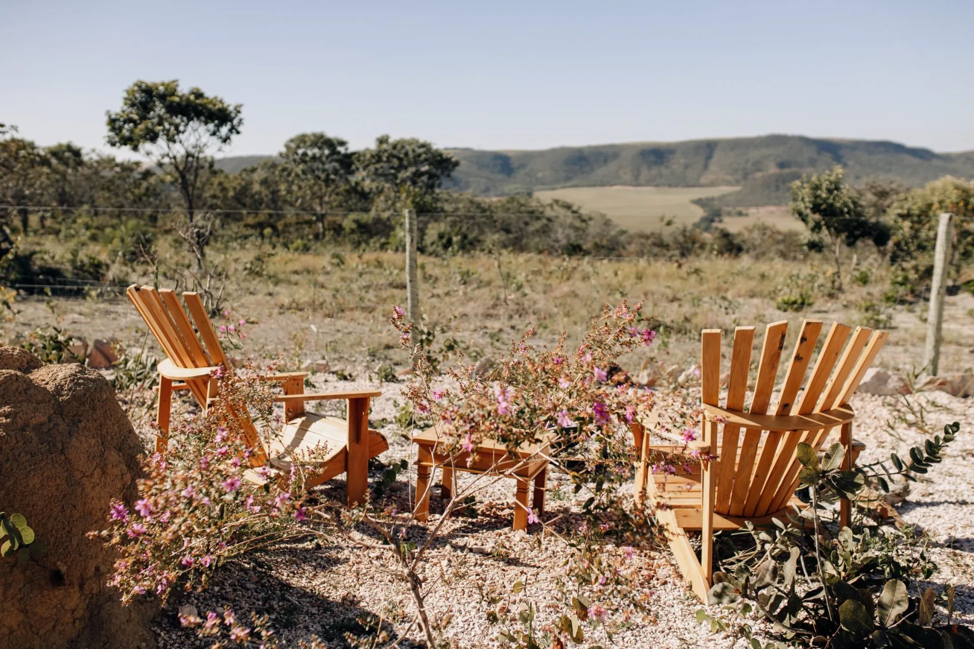 Cadeiras Adirondack com flores silvestres e vista panorâmica das chapadas e vegetação do Cerrado